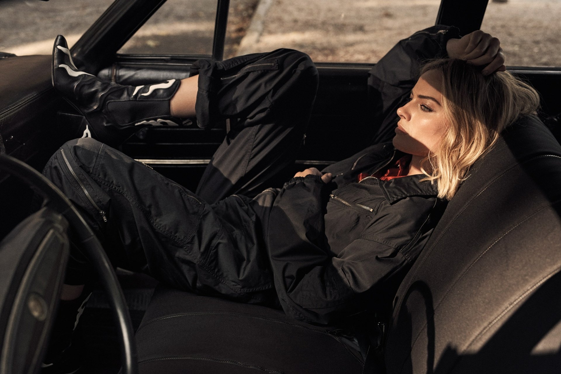 Blonde woman reclining in a vintage car, moody side-lit portrait with warm tones — 4K Ultra HD PC desktop wallpaper.