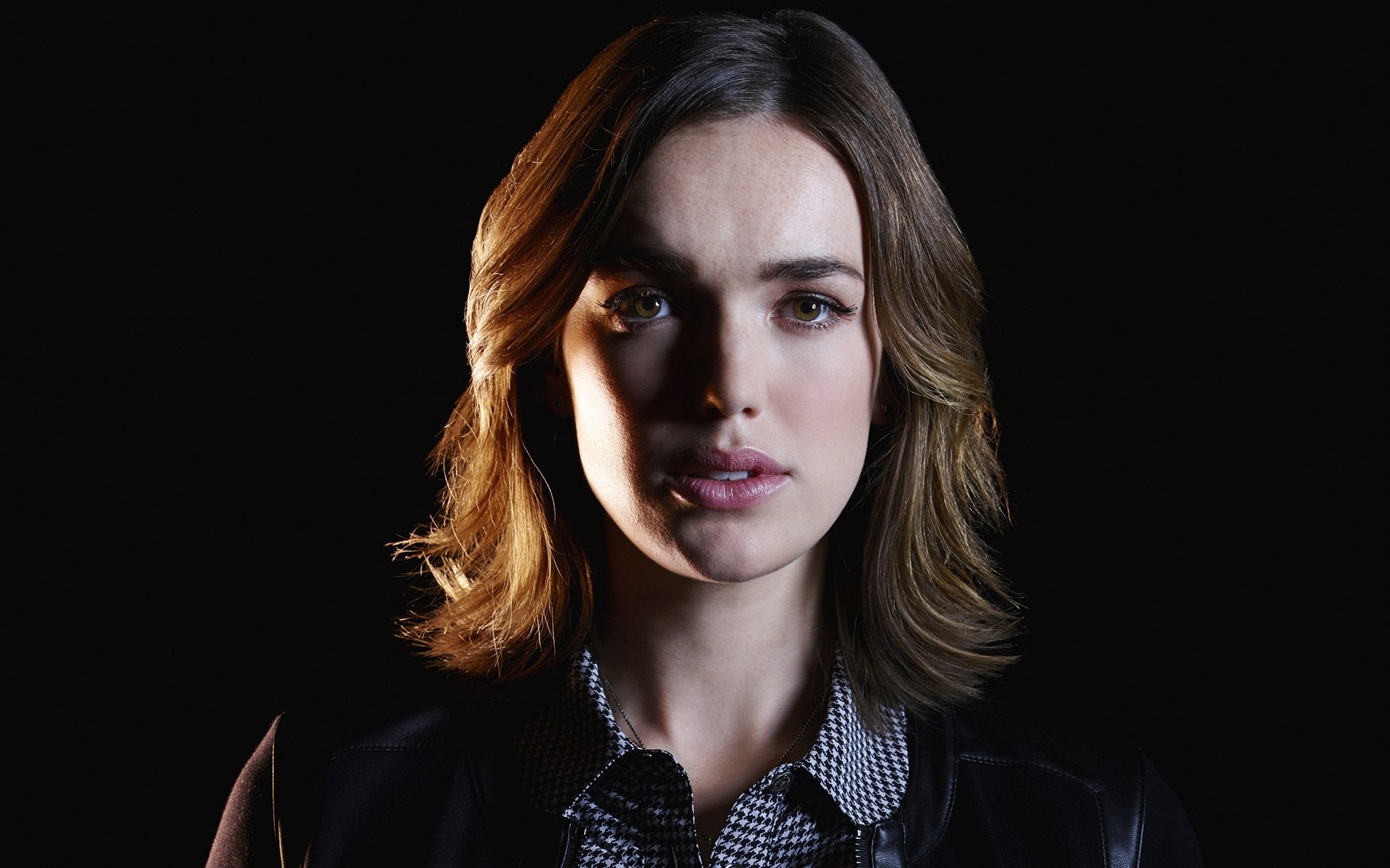 HD desktop wallpaper featuring Elizabeth Henstridge as Jemma Simmons from the TV show Agents of S.H.I.E.L.D., with a dark background highlighting her face.