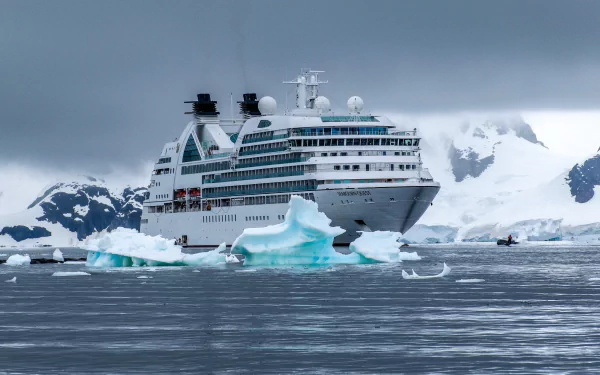 HD desktop wallpaper showing the MV Seabourn Quest cruise ship navigating icy Antarctic waters surrounded by icebergs and snow-covered mountains.