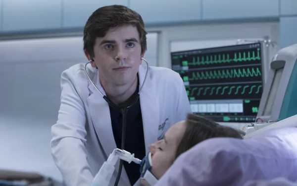 HD desktop wallpaper from The Good Doctor featuring Freddie Highmore in a medical setting, attending to a patient.
