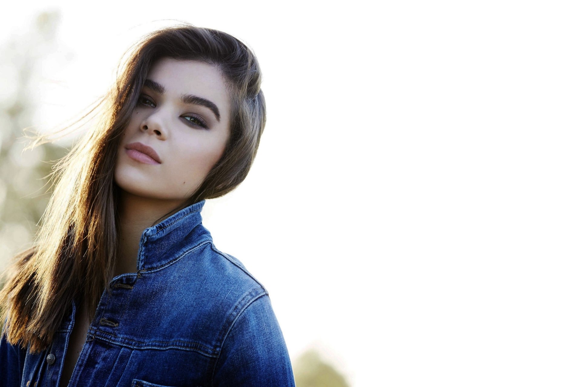HD desktop wallpaper of American singer and actress Hailee Steinfeld, showcasing a brunette in a denim jacket with a depth of field effect.