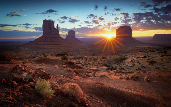 Sunrise over Monument Valley desert landscape in the USA, captured in stunning HD for a dramatic nature desktop wallpaper and background.