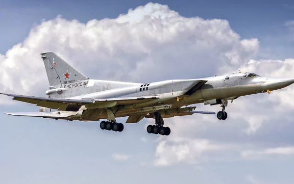 HD PC desktop wallpaper of a Tupolev Tu-22 military bomber warplane aircraft in flight against a cloudy sky, landing gear deployed.