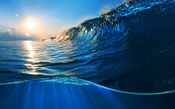 4K Ultra HD desktop wallpaper of a vibrant ocean wave catching sunlight, showcasing the dynamic beauty of nature and the sea.