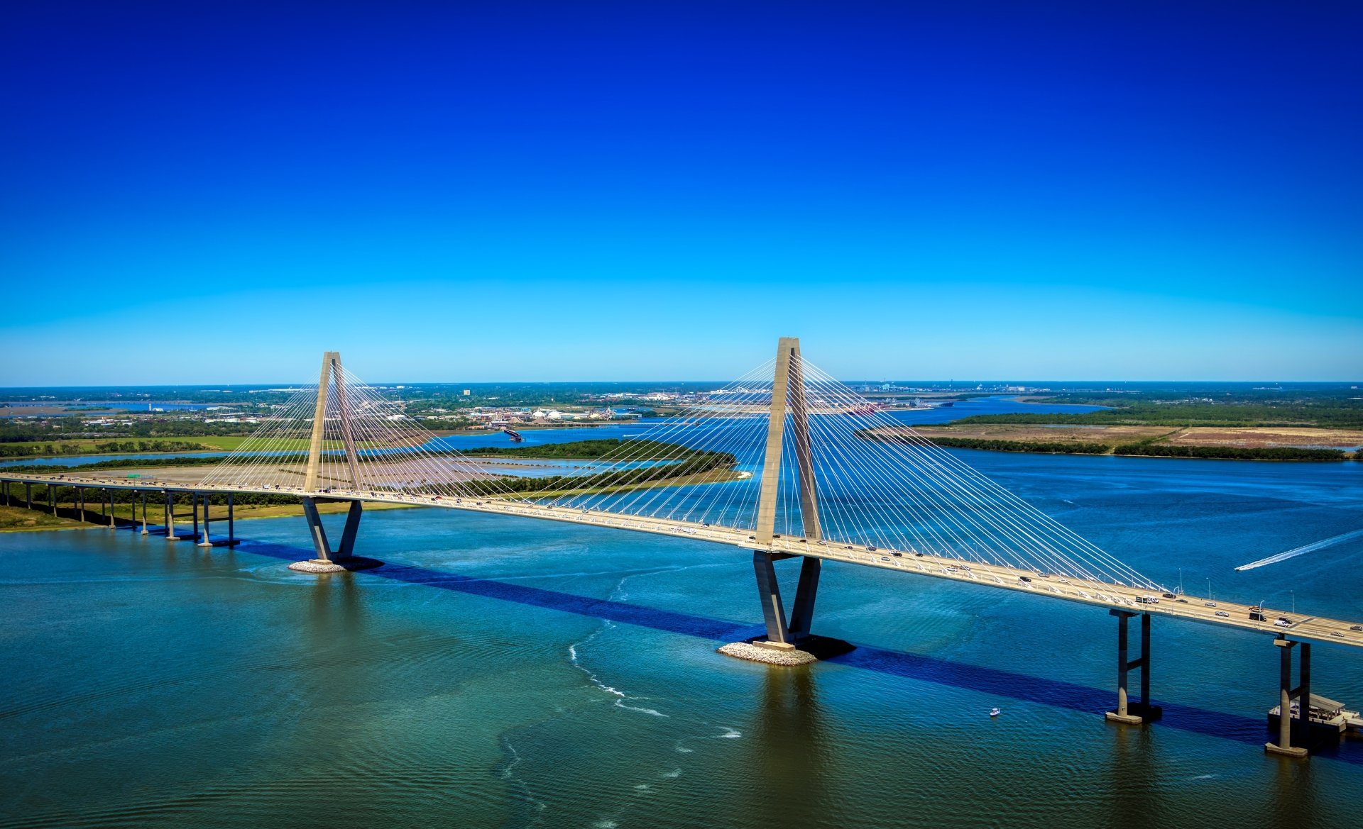A 4K Ultra HD image of a man-made bridge spanning a wide river in the USA under a clear blue sky, captured as a PC desktop wallpaper background.