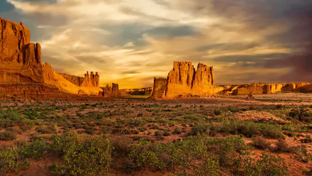 4K Ultra HD desktop wallpaper showcasing the rugged mountains and natural rock formations of Arches National Park under a dramatic sky.