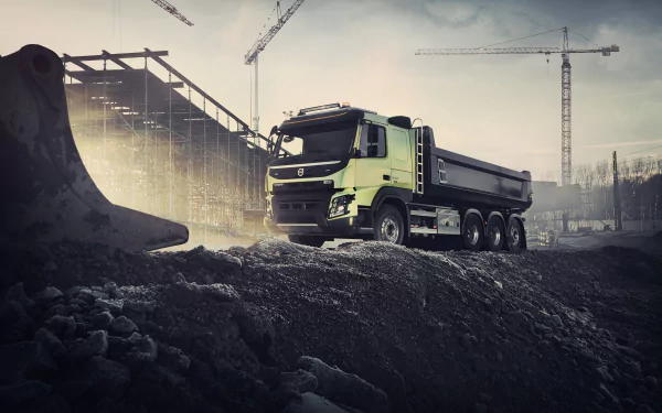 Volvo dump truck on a rugged construction site with cranes and skeletal building, dramatic lighting — 8K Ultra HD PC desktop wallpaper and background