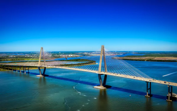 A 4K Ultra HD image of a man-made bridge spanning a wide river in the USA under a clear blue sky, captured as a PC desktop wallpaper background.