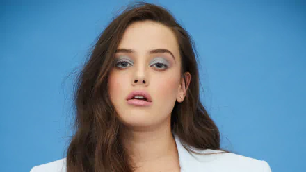 Close-up portrait of Australian actress Katherine Langford with brunette hair against a blue background, captured in 4K Ultra HD for PC desktop wallpaper.