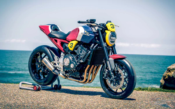 Honda CB1000R naked sportbike by the ocean, vivid 4K Ultra HD PC desktop wallpaper/background showcasing sleek black-and-red styling.
