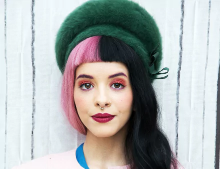 American singer Melanie Martinez wears a green hat and bold lipstick in this HD PC desktop wallpaper and background.