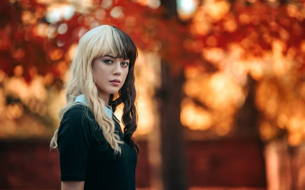 Portrait of a woman model with two-toned hair against a blurred autumn background, captured in stunning 4K Ultra HD depth of field for a PC desktop wallpaper.