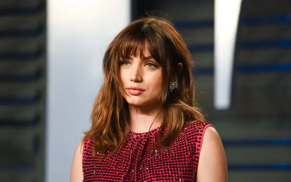 Close-up portrait of a brunette woman with bangs in a textured red dress against a soft-lit backdrop — 2K Quad HD PC desktop wallpaper.