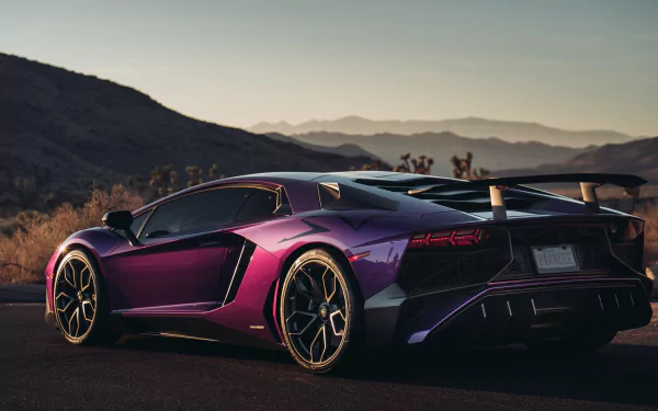 Purple Lamborghini Aventador SV supercar parked on a scenic mountain road at sunset, showcased in 4K Ultra HD as a striking PC desktop wallpaper.