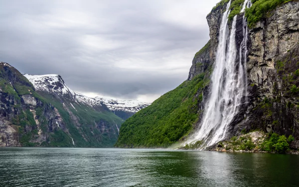 A stunning 4K Ultra HD desktop wallpaper showcasing a dramatic waterfall cascading down a Norwegian fjord mountain, surrounded by lush greenery and calm waters.