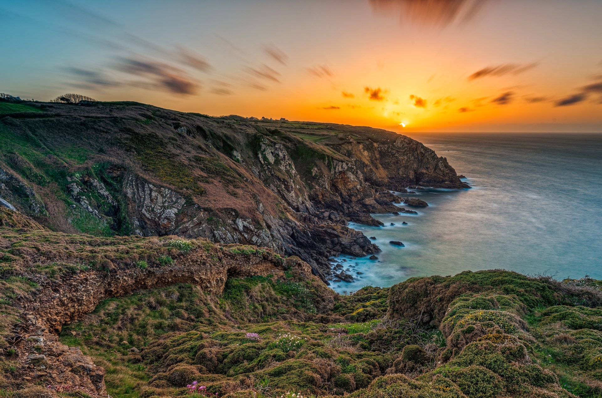 2K Quad HD desktop wallpaper: Brittany sunset over rugged French coastline, cliffs plunging to the ocean with golden sky and tranquil waves.