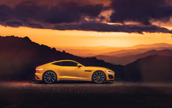 Yellow Jaguar F-Type R Coupe (Jaguar F-Type R) side profile against layered mountain sunset — 5K Ultra HD PC desktop wallpaper and background, vehicle shot.