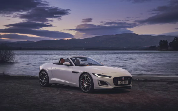 White Jaguar F-Type convertible parked by a lakeside at dusk, captured in stunning 4K Ultra HD for a PC desktop wallpaper.