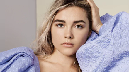 Close-up HD desktop wallpaper of English actress Florence Pugh with blonde hair, wearing a textured lavender garment, showcasing a calm and natural expression.