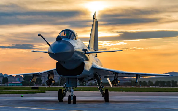 HD desktop wallpaper of a Chengdu J-10 military jet fighter warplane on the runway at sunset, showcasing the sleek aircraft against a dramatic sky.