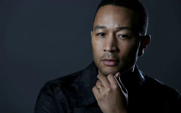 HD desktop wallpaper featuring a contemplative man against a dark background.