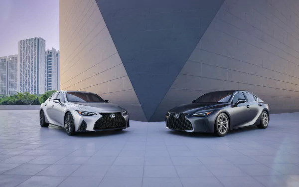 Silver and black Lexus IS cars parked symmetrically before a modern angular building — a 5K Ultra HD PC desktop wallpaper of Lexus vehicles.