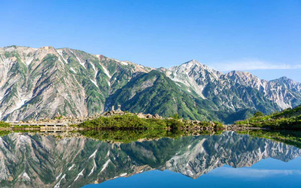 HD PC desktop wallpaper/background: Hakuba, Japan — alpine mountains and green slopes reflected in a crystal lake under a clear blue sky.