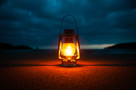A glowing man-made kerosene lamp lantern illuminates a dark landscape, captured in a 4K Ultra HD PC desktop wallpaper and background.