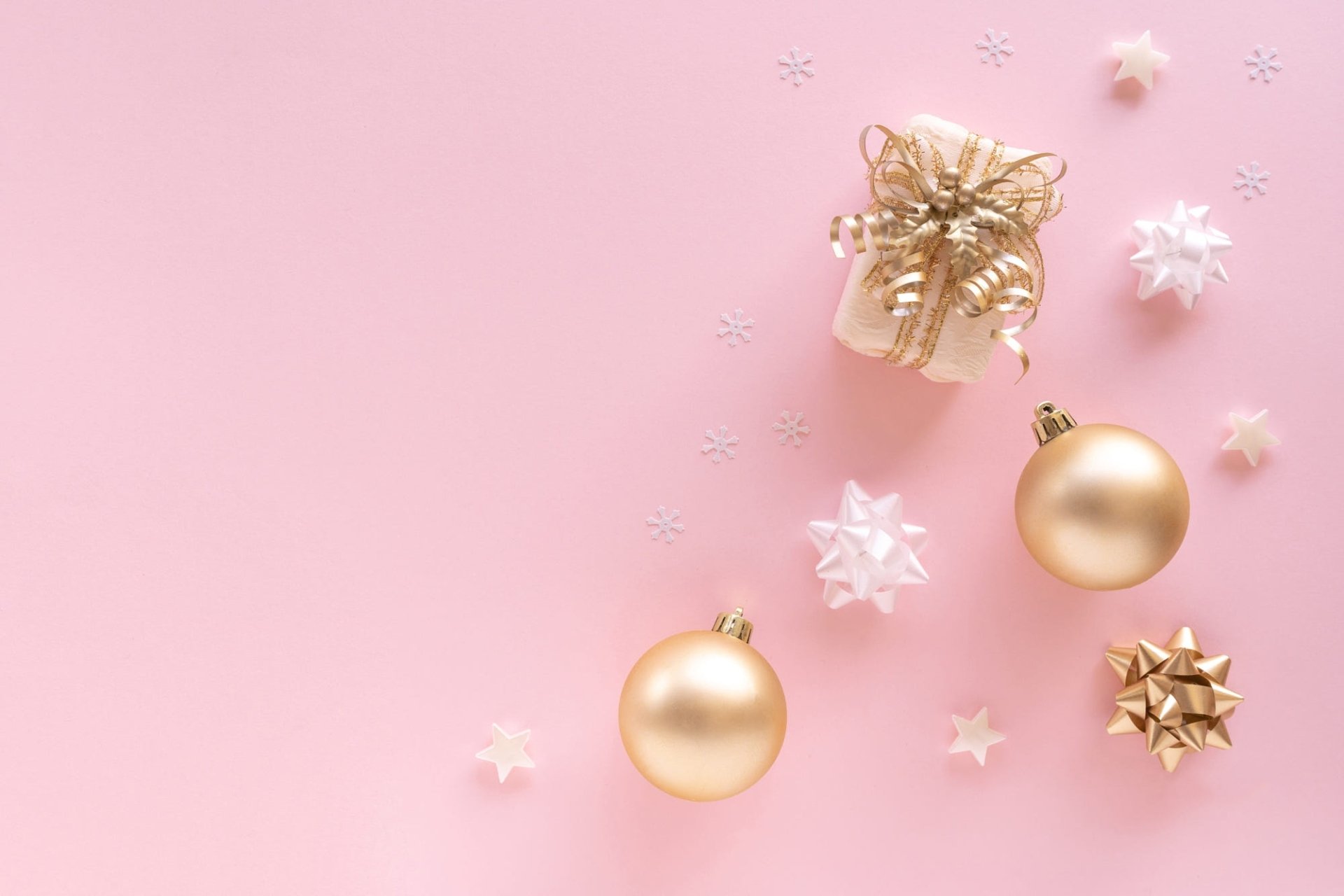 HD PC desktop wallpaper: pink Christmas holiday background with gold baubles, wrapped gift box, stars and small snowflake ornaments.