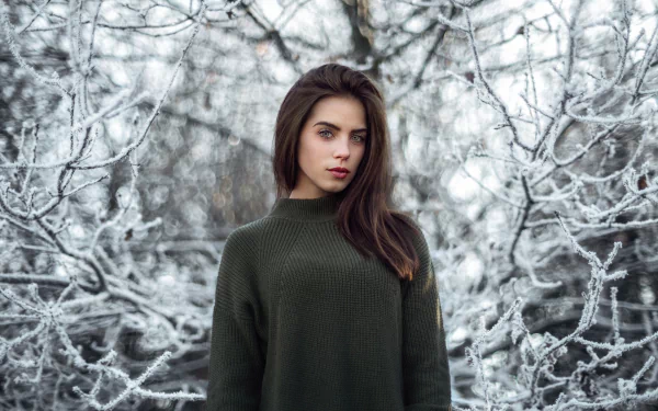 Brunette woman wearing a dark green sweater stands against a snowy winter background, captured in an HD PC desktop wallpaper by Marlen Valderrama Alvaréz.