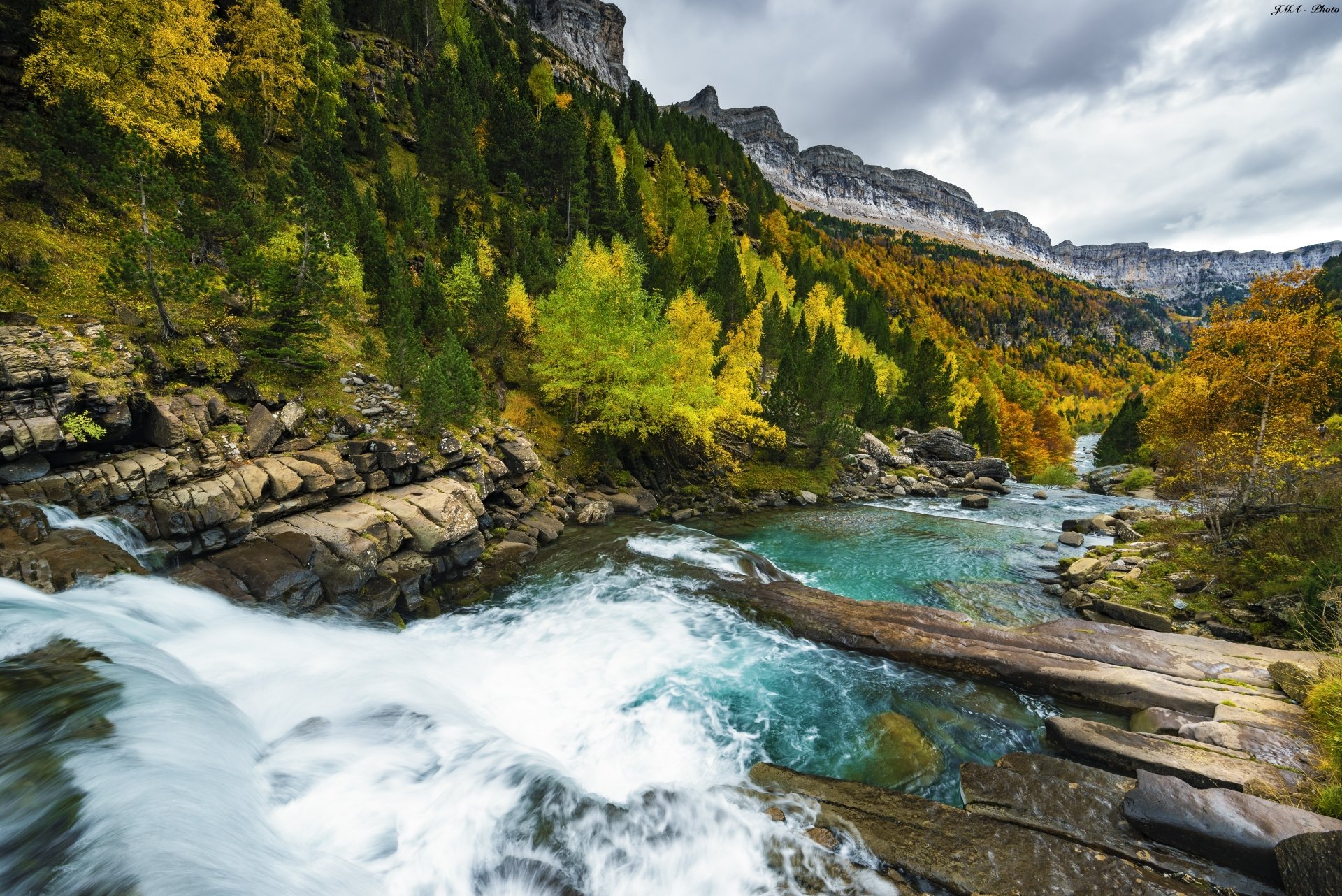 5K Ultra HD PC desktop wallpaper and background of a Spanish national park: waterfall cascading into turquoise pools through an autumn mountain forest, a vivid nature landscape.