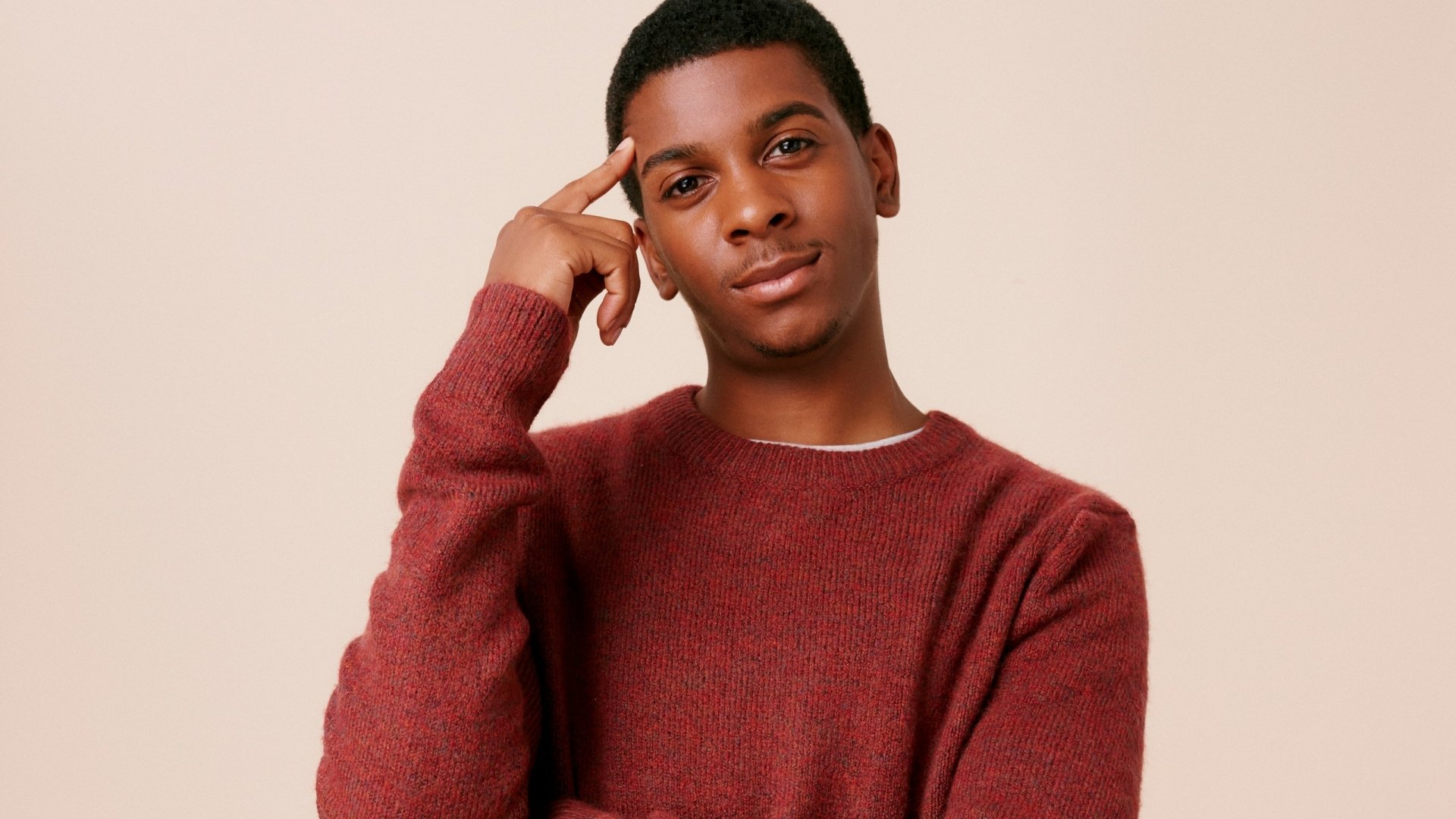 HD desktop wallpaper featuring a person in a red sweater, posing with a thoughtful expression, suitable as a background.