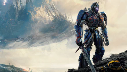 HD desktop wallpaper features Optimus Prime from Transformers: The Last Knight, standing heroically amidst a dramatic, cloudy landscape with sharp mountains in the background.