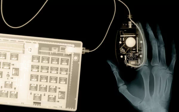 An X-ray vision themed HD desktop wallpaper showcasing a hand holding a computer mouse with internal circuitry visible.