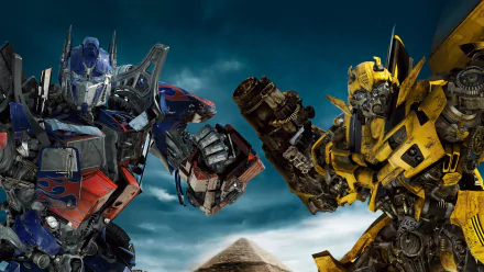 HD desktop wallpaper featuring Optimus Prime and Bumblebee from the movie Transformers: Revenge of the Fallen, set against a dramatic, cloud-filled sky.
