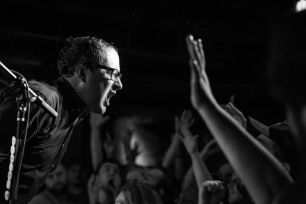 HD desktop wallpaper featuring a monochrome shot of The Hold Steady's lead singer in a live performance connecting with the audience.