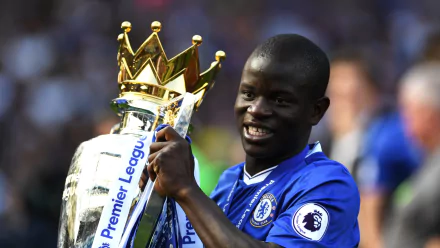 HD PC desktop wallpaper of N'Golo Kanté in a blue Chelsea jersey holding the Premier League trophy, celebrating a sports victory.