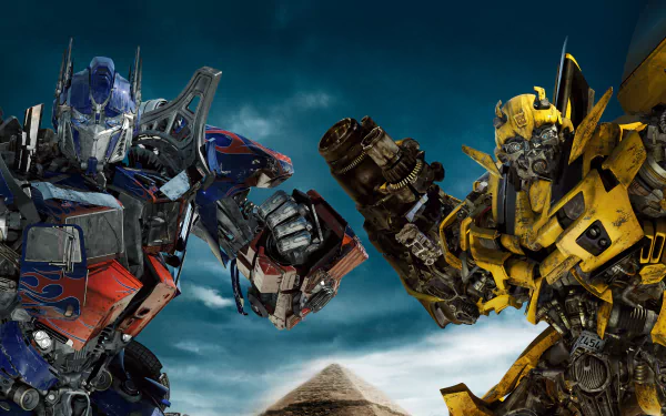 HD desktop wallpaper featuring Optimus Prime and Bumblebee from the movie Transformers: Revenge of the Fallen, set against a dramatic, cloud-filled sky.