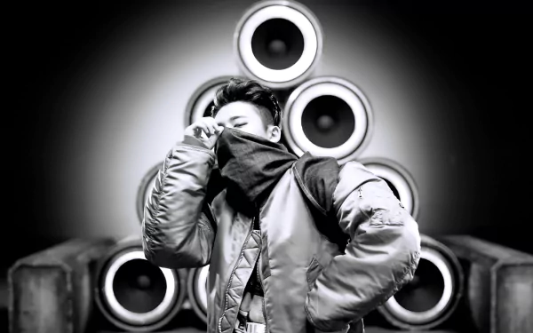 HD desktop wallpaper featuring a monochrome image of a person with iKON style, posing in front of an array of speakers.