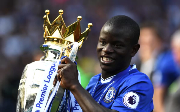 HD PC desktop wallpaper of N'Golo Kanté in a blue Chelsea jersey holding the Premier League trophy, celebrating a sports victory.