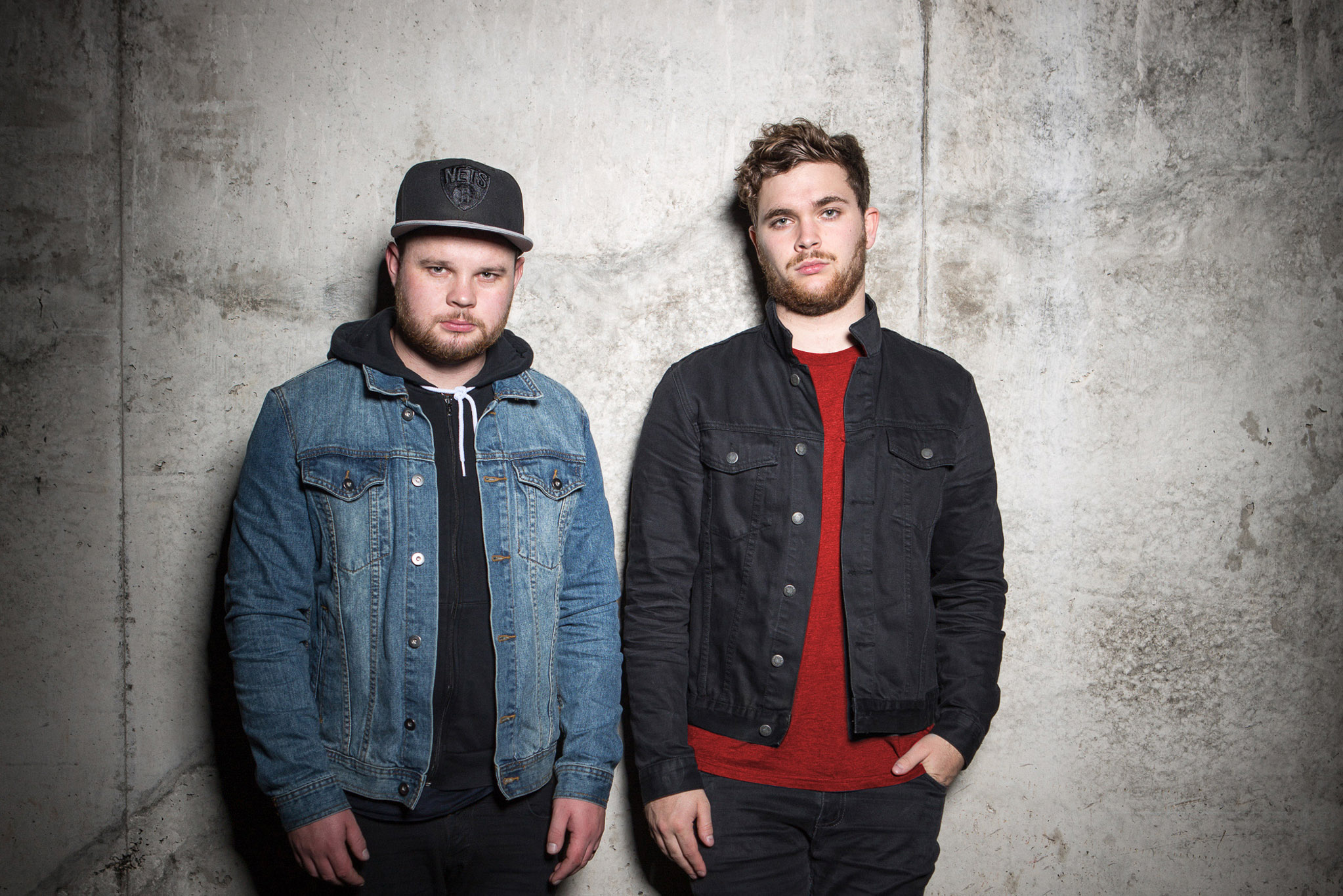 HD wallpaper featuring two members of the band tagged as Royal Blood standing against a textured concrete wall, ideal for a desktop background.