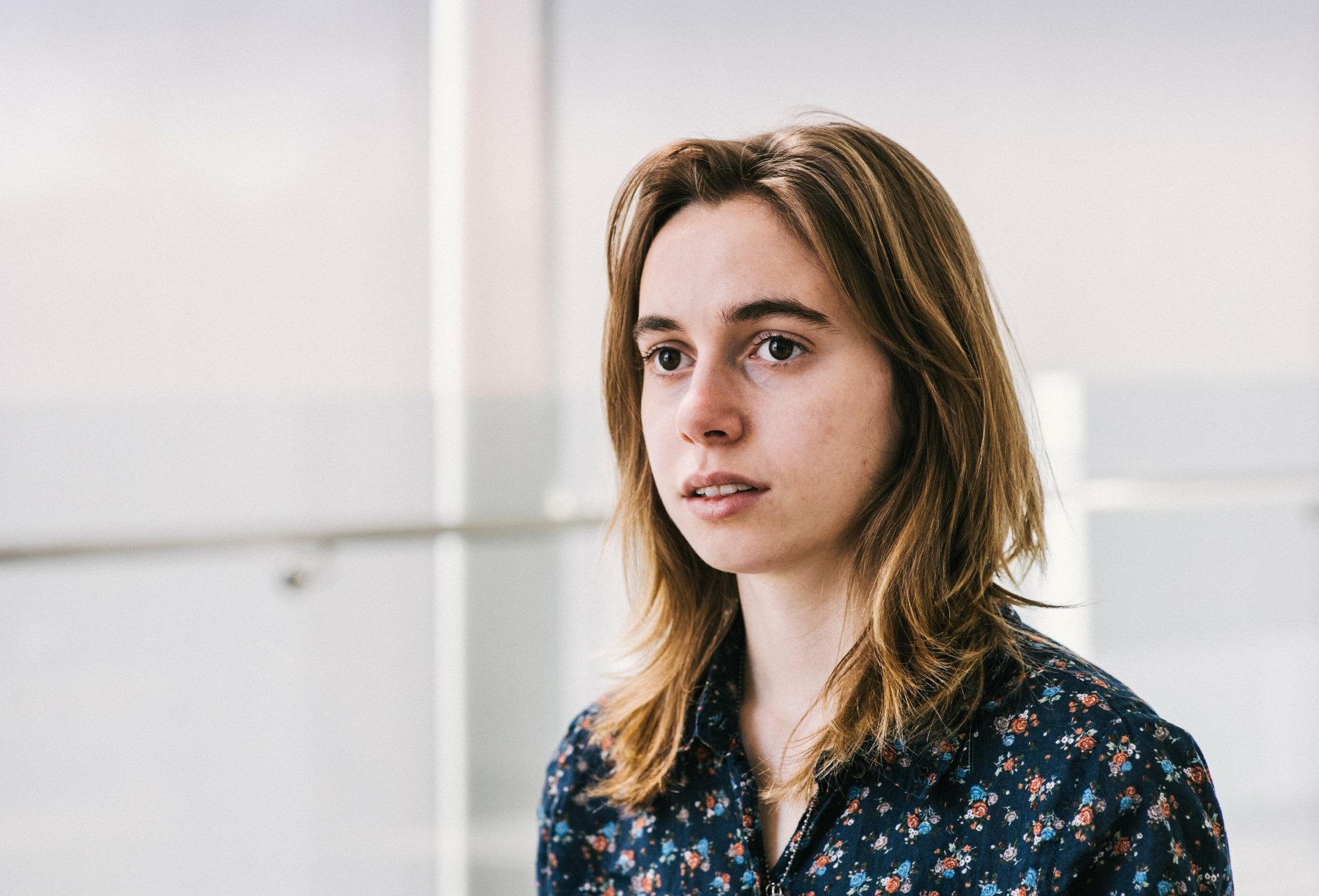 HD desktop wallpaper featuring a contemplative individual in a floral shirt, suitable as a background, tagged with Julien Baker.