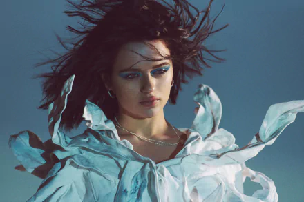 Unidentified brunette American woman posed as an actress, wind-tousled hair and dramatic makeup in a flowing blouse — 4K Ultra HD desktop wallpaper.