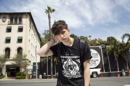 HD wallpaper featuring a young man posing in front of a building with palm trees in the background, tagged as Porter Robinson.