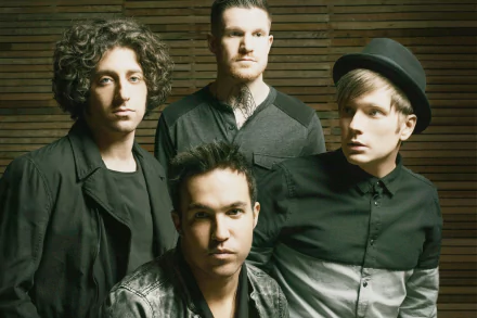 High-definition desktop wallpaper featuring a group of four band members posing against a wooden backdrop, tagged as Fall Out Boy.