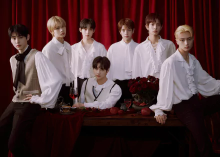 Seven men in white ruffled shirts pose before red velvet curtains with roses and wine — music-themed K-pop group 2K Quad HD PC desktop wallpaper and background.