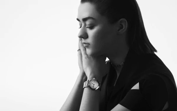 Black-and-white 2K desktop wallpaper of a contemplative woman in profile, hands near her face, wearing a wristwatch in a portrait-style studio shot.