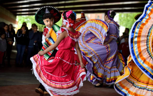 Colorful Mexican dance performance, with dancers in traditional dresses and a sombrero, as a vibrant HD desktop wallpaper.
