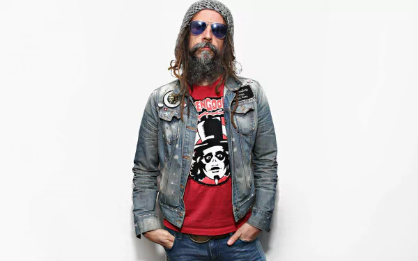 HD wallpaper featuring a person with long hair, sunglasses, and a denim jacket, set against a white background, associated with Rob Zombie.