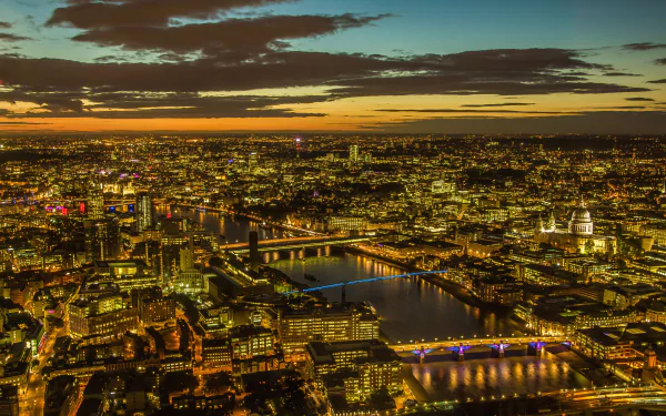 5K Ultra HD PC desktop wallpaper and background: aerial night view of London city, showcasing a man-made skyline along the Thames with illuminated bridges and glowing buildings.